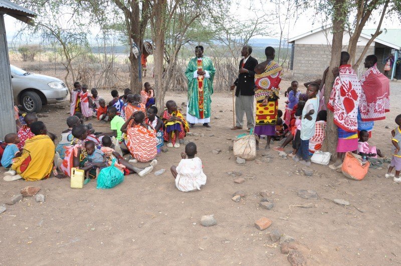 A Carmelite priest in Africa speaking to a village congregation.